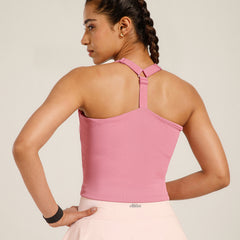 Woman wearing a pink top with thin straps on a plain background
